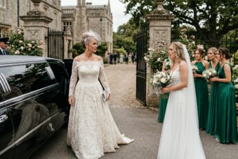 Mother-in-law in a white lace dress stepping out of a limousine at the wedding